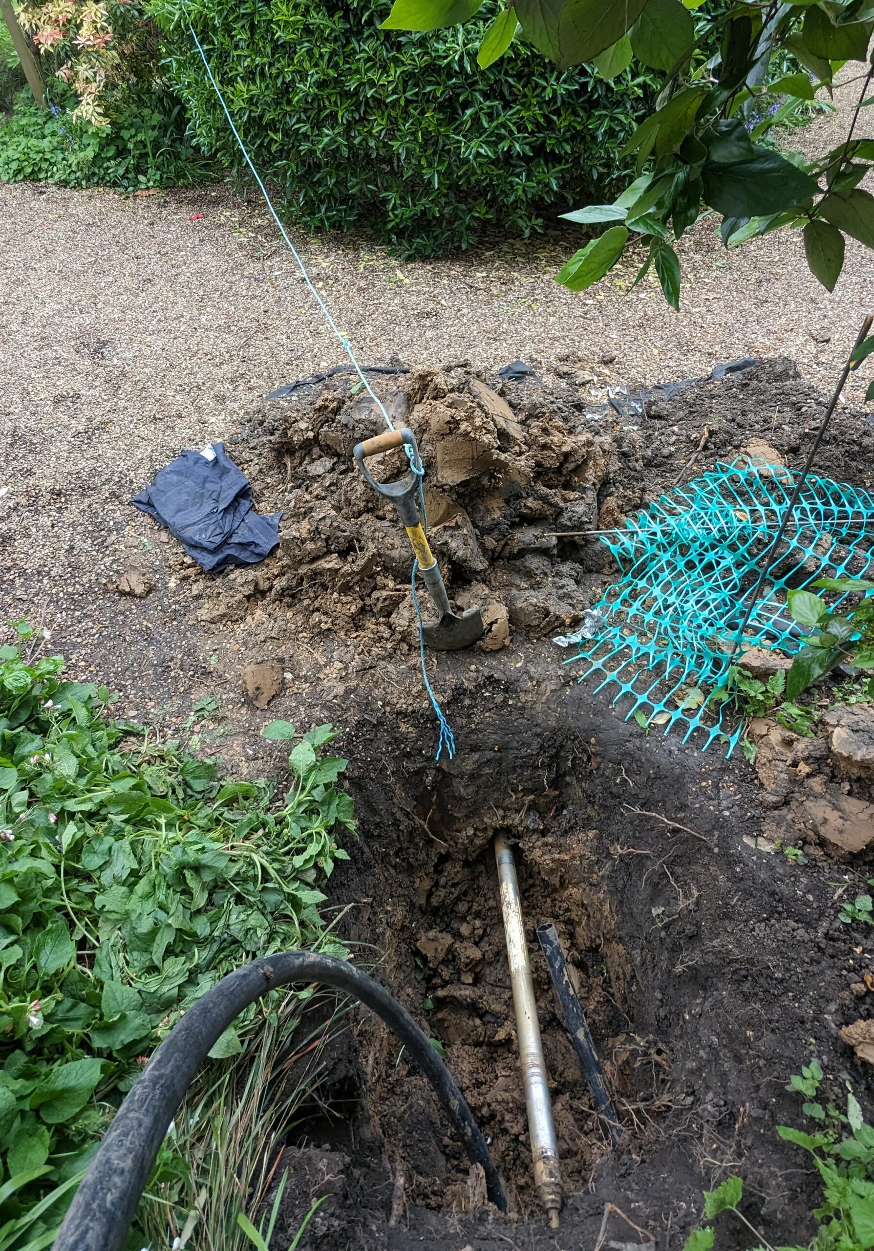 A GardenSqua.re moling access pit and air hose beside an established garden path